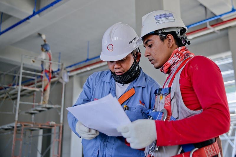 Two people wearing safety helmets